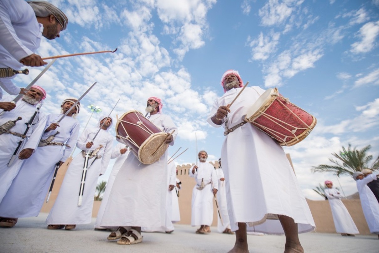 Dancing Omanis in a white dishdasha with drums in their hands