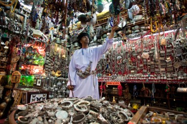 An Omani at a jewellery stand in the Mutrah Souq, surrounded by jewellery