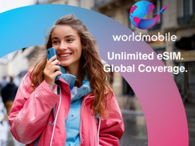 Eine junge Frau die lächelt und ein Handy in der Hand hält und der Schriftzug: worldmobile / Unlimited eSIM / Global Coverage