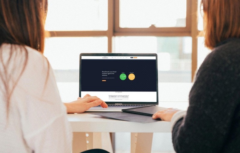 Two women at a computer, looking at a website. 