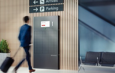 Eine Person geht auf eine Sharebox zu, die sich in einem Flughafen befindet.