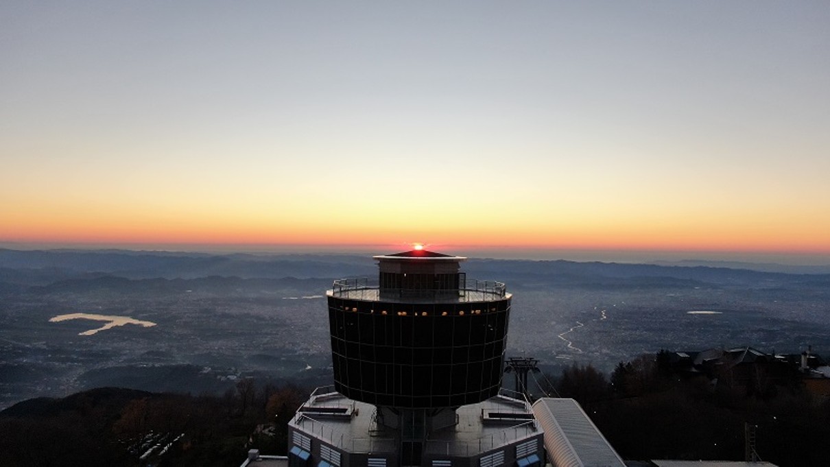 Sonnenuntergang am Horizont, ein Gebäude im Schatten.