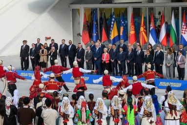 State representatives in front of the respective flags, Albanian dancers in the foreground. 