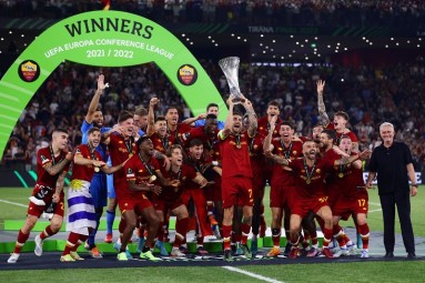 The winning team of the UEFA Europa Conference League celebrating with a trophy in their hands.