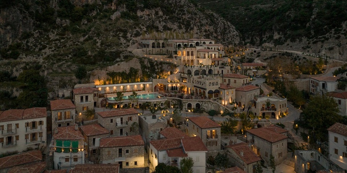 Ein Dorf in Albanien in der Abenddämmerung mit den Lichtern der Häuser. 