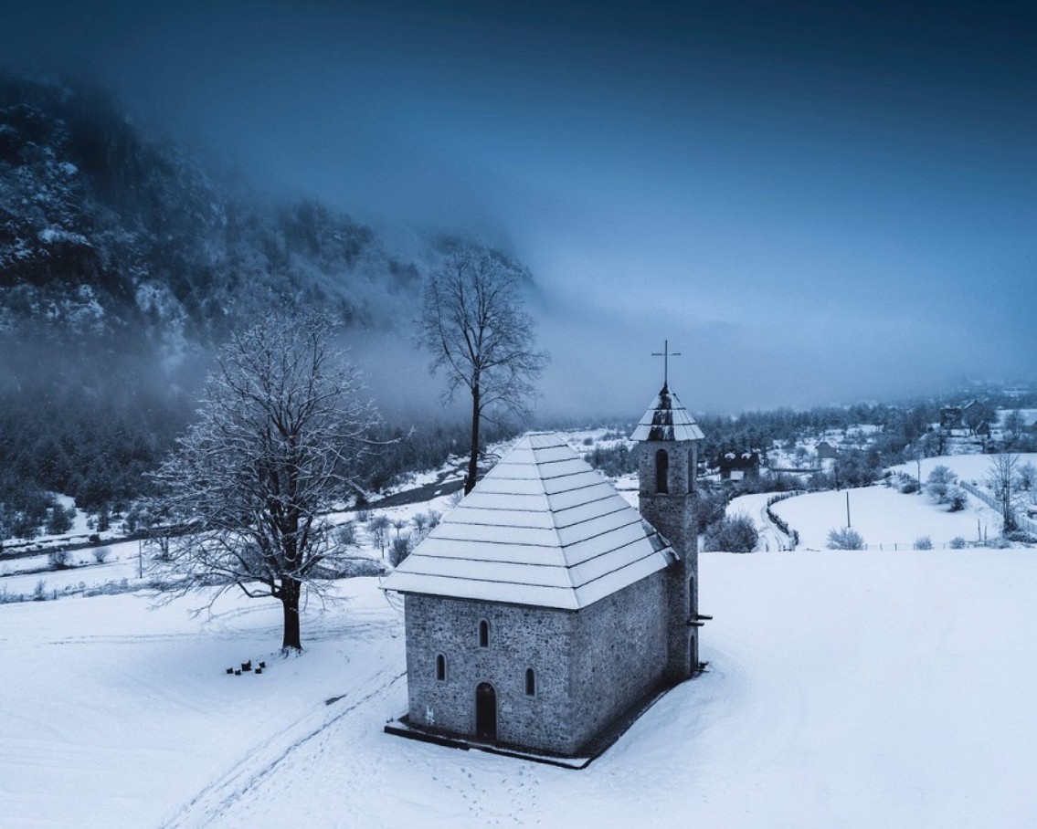 Eine Kirche auf dem Land in einer verschneiten Gegend.