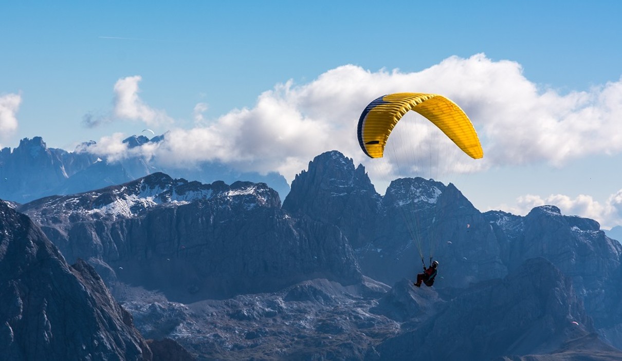 A person who flies over mountains with a paraglider. 